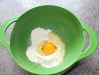 Egg broken into well in flour.